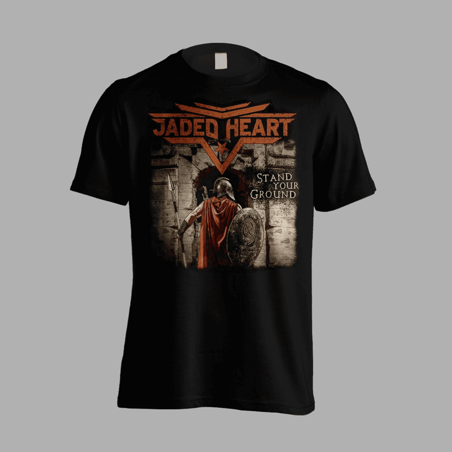 Jaded Heart T-Shirt 'Stand Your Ground' features a warrior with shield and spear at a stone gate, bold band logo and title on front. Ideal for rock fans.