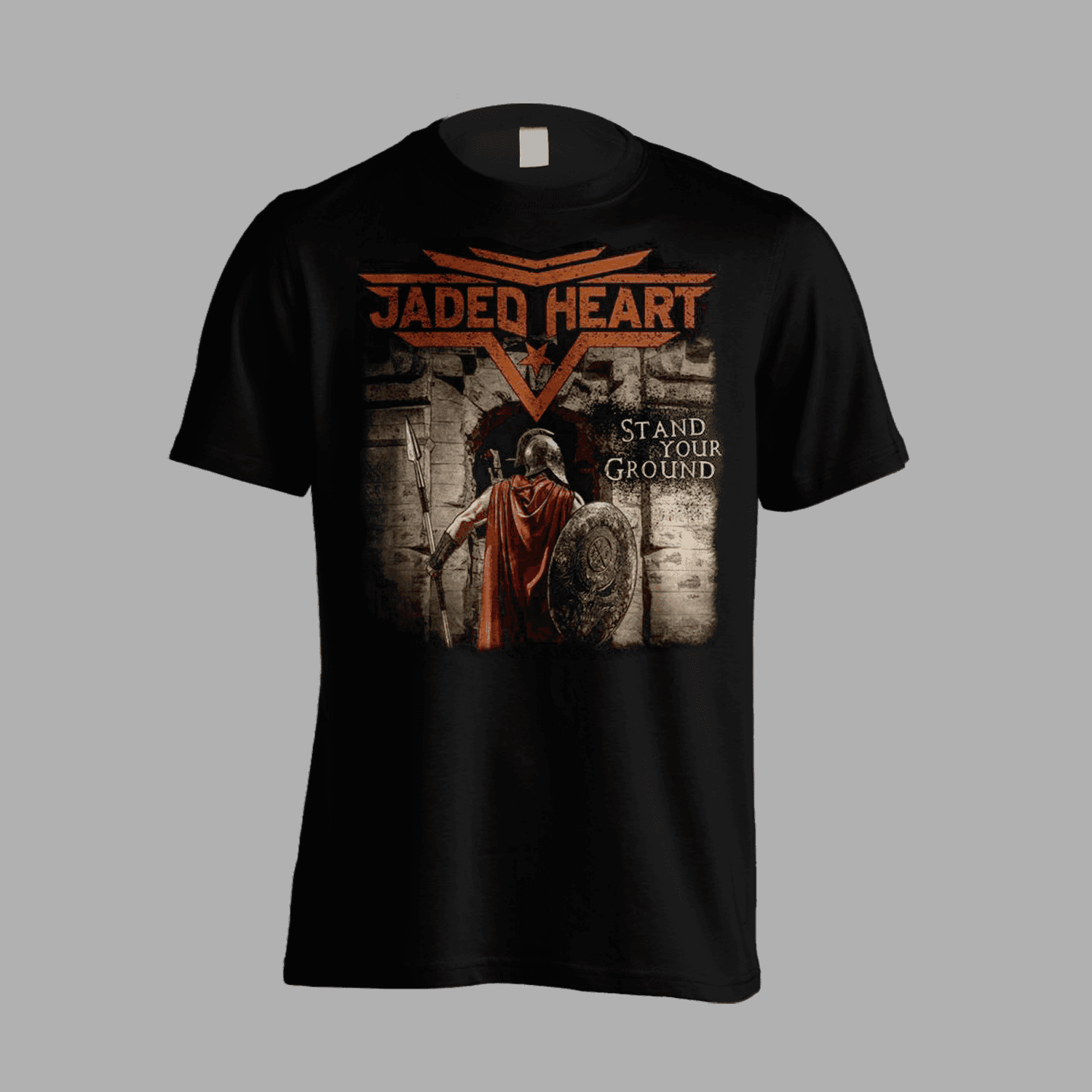 Jaded Heart T-Shirt 'Stand Your Ground' features a warrior with shield and spear at a stone gate, bold band logo and title on front. Ideal for rock fans.