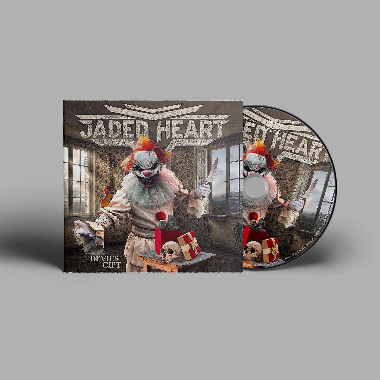 Jaded Heart CD 'Devil's Gift' digipack featuring a sinister clown with a knife, skull, and gift box in a dark room. Heavy metal music CD.